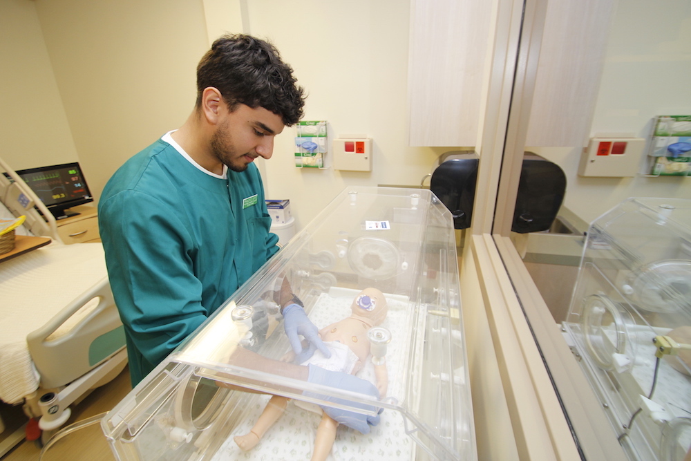 A male nursing 첥 works with an infant simulation